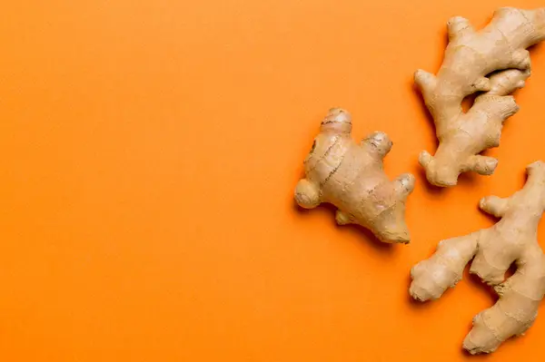 Finely dry Ginger powder in bowl with green leaves isolated on colored background. top view flat lay.