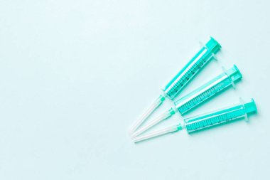 Renkli arkaplanda fotokopi alanı olan tıbbi enjeksiyon için üst sıradaki şırıngaların görüntüsü. Sağlık ve aşı kavramı.