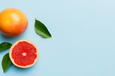 Renkli arka planda sulu greyfurt dilimli taze meyve greyfurdu. Üst Manzara. Uzayı kopyala yaratıcı yaz konsepti. Minimum düzlükte turunçgillerin yarısı kopyalama alanı ile yatar.