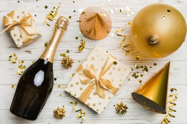 Renkli arka planda şampanya şişesi hediye paketi kurdeleleri ve konfetilerin düz kompozisyonu vardı. Düz konum, üst görünüm tatil konsepti.