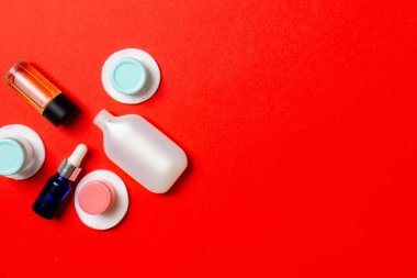 Renkli arka planda seyahat boyutunda kozmetik şişeler. Krema kavanozları düzdü. Vücut bakım stili kavramının en üst görünümü.