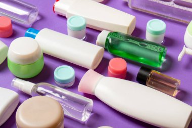 Renkli arka plandaki kozmetik ürünleri için farklı boyutlarda şişeler ve kavanozlar. Fotokopi alanı ile yüz ve vücut bakımı kavramı.