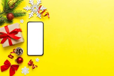 Digital phone mock up with rustic Christmas decorations for app presentation top view with empty space for you design. Christmas online shopping concept. Tablet with copy space on colored background.