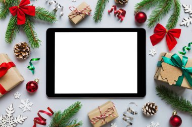 Digital tablet mock up with rustic Christmas decorations for app presentation top view with empty space for you design. Christmas online shopping concept. Tablet with copy space on colored background.