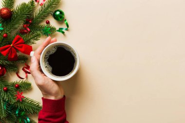Elinde bir fincan kahve tutan kadın. Kadın elleri bardağı sıcak kahveyle tutuyor. Kış ve Noel zamanı kavramı.