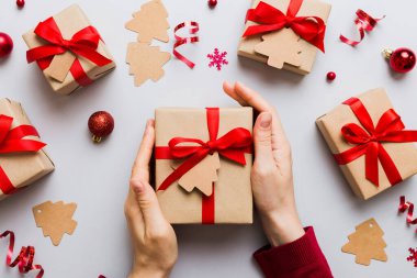 Kadın eli hediye kutusunu tutuyor, sürprizi hazırlıyor, üst manzara, Noel ve yeni yıl konsepti.