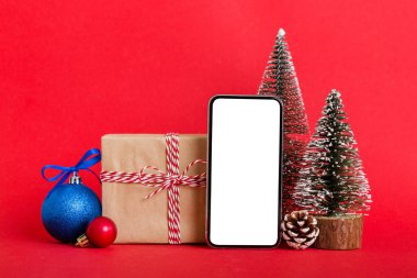 Digital phone mock up with rustic Christmas decorations for app presentation with empty space for you design. Christmas online shopping concept. Tablet with copy space on colored background.