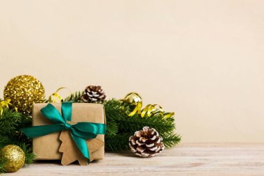 New Year Christmas mood, gift box, branches of a christmas tree, New Year decorations on a colored background.