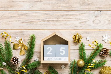 Christmas calendar 25 december. Christmas gift, fir branches, pine cones. Flat lay, top view. New Year decorations on a colored background.