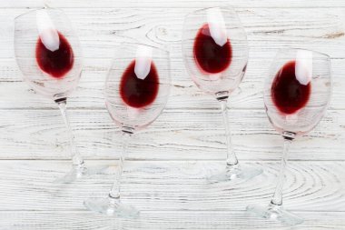 Şarap tadımında bir sürü kırmızı şarap. Renkli arka planda kırmızı şarap kavramı. Üst görünüm, düz dizayn.