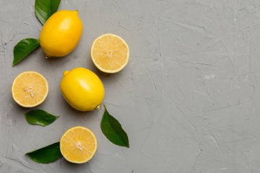 Renkli arka planda yeşil yapraklı taze limonlar, üst görünüm, metin için boşluk.