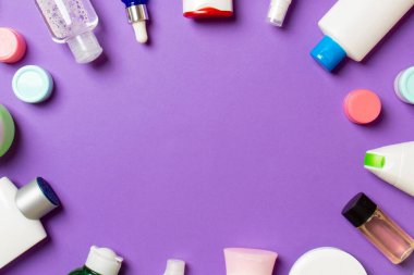 Plastik vücut bakım şişesi çerçevesi düz kompozisyonda renkli arka plan boşluğunda sizin tasarımınız için kozmetik ürünler sergileniyordu. Beyaz Kozmetik kapları kümesi, kopya alanı ile üst görünüm.