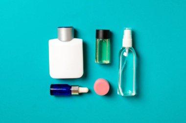 Kozmetik SPA marka modeli, fotokopi alanı olan üst görünüm. Renkli arka planda duran krema tüpleri ve kavanozları..