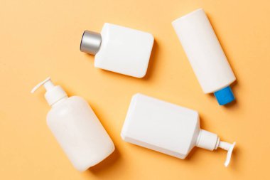 Renkli arkaplanda izole edilmiş Beyaz Kozmetik konteynırları seti, fotokopi alanı ile üst görünüm. Senin için bir grup plastik kaplar ve boş bir yer tasarladın..