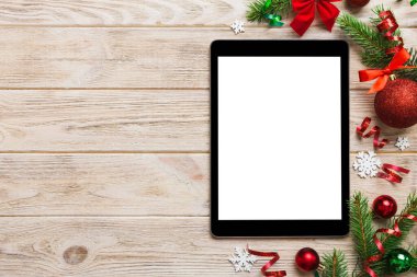 Digital tablet mock up with rustic Christmas decorations for app presentation top view with empty space for you design. Christmas online shopping concept. Tablet with copy space on colored background.