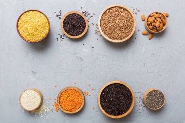 Smal Bowl 'da renkli arka planda çeşitli süper yiyecekler. Pirinç, chia, kinoa, mercimek, fındık, susam tohumu, badem gibi süper yiyecekler. üst görünüm kopyalama alanı.