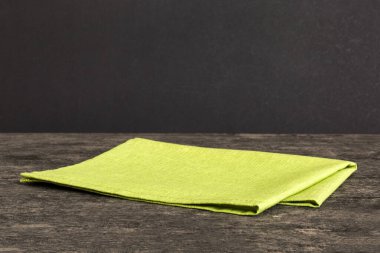 top view with green kitchen napkin isolated on table background. Folded cloth for mockup with copy space, Flat lay. Minimal style.