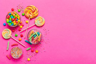 Lezzetli İştah açıcı Parti Aksesuarları Mutlu Yıllar Tatlı. Renkli arkaplanda farklı tipte şekerler, kopyalama alanı. Renkli doğum günü partisi geçmişi.