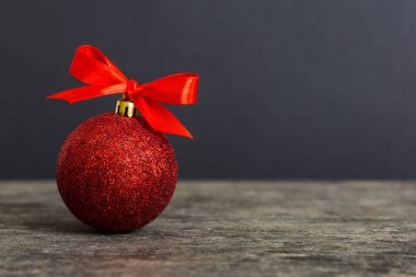 Christmas ball on colored background. decoration bauble with ribbon bow with copy space.