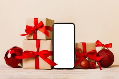 Digital phone mock up with rustic Christmas decorations for app presentation with empty space for you design. Christmas online shopping concept. Tablet with copy space on colored background.