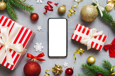Digital phone mock up with rustic Christmas decorations for app presentation top view with empty space for you design. Christmas online shopping concept. Tablet with copy space on colored background.