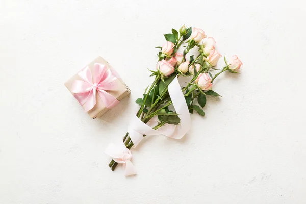 design concept with pink rose flower and gift box on colored table background top view. Happy Holiday, Mothers day, birthday concept. Romantic flat lay composition.