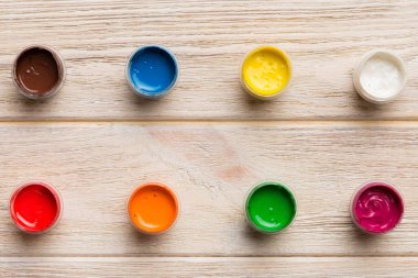 Renkli arka planda farklı renkte gagalı kavanozlar. Hobi resim. Boşluğu olan üst görünüm. Yaratıcılık için işyeri. ev öğretmenliği kavramı çizimi.