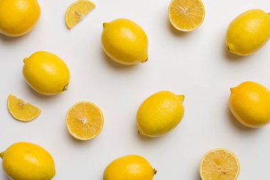 Renkli arka plan olarak pek çok taze limon, üst manzara. Limon ve limon dilimlerinin zarif arka planı Üst görünüm düz yatıyordu.