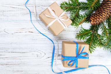 Noel hediye kutusu beyaz ahşap masa arka plan, Ladin şube, çam kozalakları, çerçeve, üstten görünüm, metin için yer.