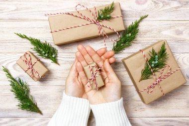 Noel hediye kutusu ahşap masa üstündeki kaydırma eller. Üstten Görünüm.