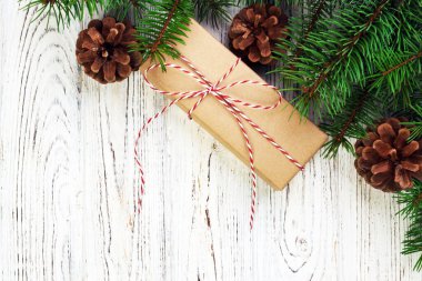 Noel kompozisyon geçmişi. Noel hediyesi olarak çam kozalakları ve tahta arka planda köknar dalları. Düz konum, üst görünüm, kopyalama alanı. Ayarlanmış.