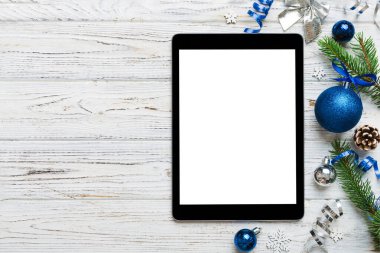 Digital tablet mock up with rustic Christmas decorations for app presentation top view with empty space for you design. Christmas online shopping concept. Tablet with copy space on colored background.