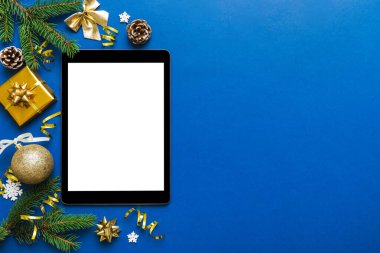 Digital tablet mock up with rustic Christmas decorations for app presentation top view with empty space for you design. Christmas online shopping concept. Tablet with copy space on colored background.