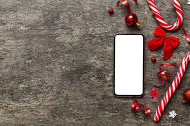 Digital phone mock up with rustic Christmas decorations for app presentation top view with empty space for you design. Christmas online shopping concept. Tablet with copy space on colored background.