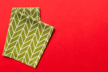 top view with green kitchen napkin isolated on table background. Folded cloth for mockup with copy space, Flat lay. Minimal style.