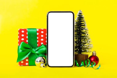Digital phone mock up with rustic Christmas decorations for app presentation with empty space for you design. Christmas online shopping concept. Tablet with copy space on colored background.