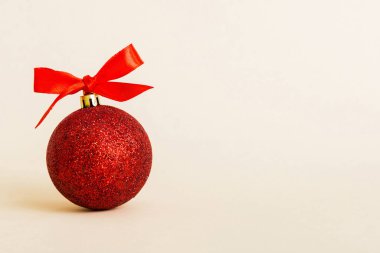 Christmas ball on colored background. decoration bauble with ribbon bow with copy space.