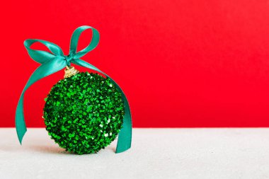 Christmas ball on colored background. decoration bauble with ribbon bow with copy space.