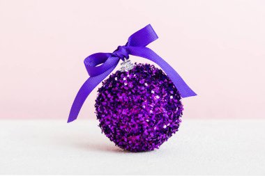 Christmas ball on colored background. decoration bauble with ribbon bow with copy space.