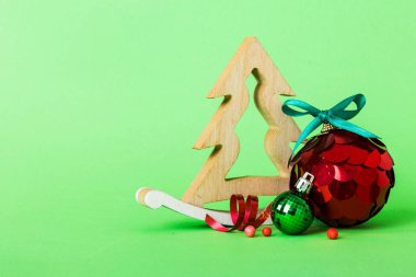 Christmas ball with decorative wooden tree on colored background. decoration bauble with ribbon bow with copy space.