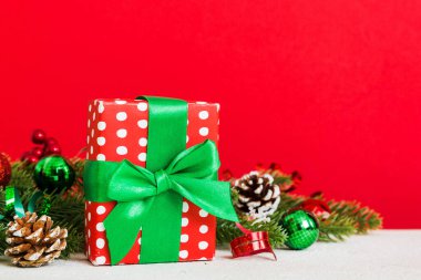 New Year Christmas mood, gift box, branches of a christmas tree, New Year decorations on a colored background.