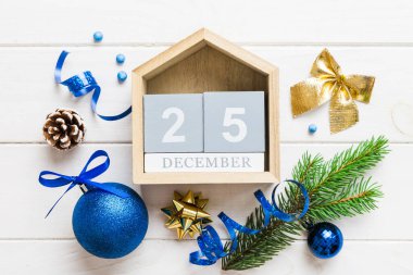 Christmas calendar 25 december. Christmas gift, fir branches, pine cones. Flat lay, top view. New Year decorations on a colored background.