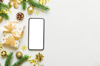 Digital phone mock up with rustic Christmas decorations for app presentation top view with empty space for you design. Christmas online shopping concept. Tablet with copy space on colored background.