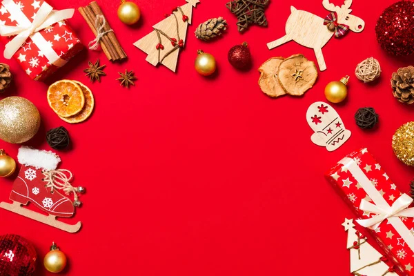 Kırmızı arka plandaki Noel süslemelerinin en üst görüntüsü. Fotokopi alanı olan yeni yıl tatili kavramı.