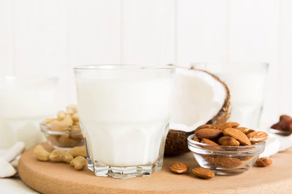 Set or collection of various vegan milk almond, coconut, cashew, on table background. Vegan plant based milk and ingredients, top view.