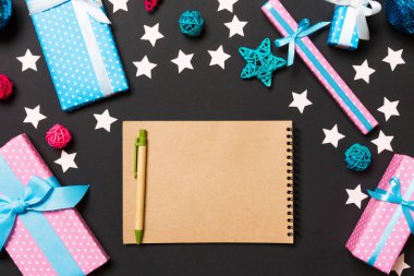 Noel süslemelerinden yapılmış siyah arkaplandaki defterin üst görüntüsü. Yeni yıl konsepti.