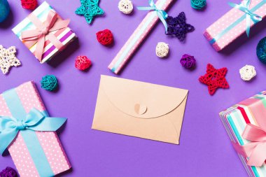 Mor arkaplandaki zarfın üst görüntüsü. Yeni yıl süslemeleri. Noel tatili kavramı.