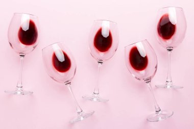 Şarap tadımında bir sürü kırmızı şarap. Renkli arka planda kırmızı şarap kavramı. Üst görünüm, düz dizayn.