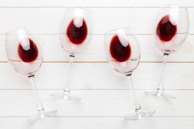 Şarap tadımında bir sürü kırmızı şarap. Renkli arka planda kırmızı şarap kavramı. Üst görünüm, düz dizayn.