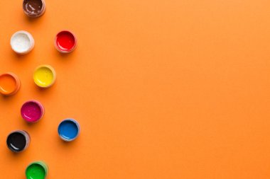 Renkli arka planda farklı renkte gagalı kavanozlar. Hobi resim. Boşluğu olan üst görünüm. Yaratıcılık için işyeri. ev öğretmenliği kavramı çizimi.